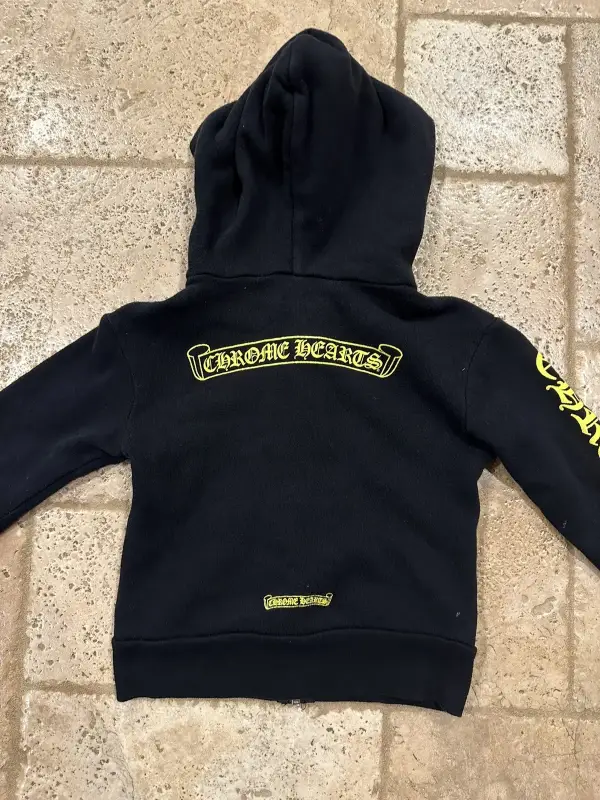 Chrome Hearts Kids Yellow Zip-up Black Hoodie back view highlighting the iconic yellow plus cross motifs and scroll branding.