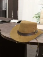 1923 Spencer Dutton brown suede safari fedora with leather buckle band resting on wooden desk lifestyle product shot