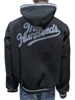 Model wearing The Hundreds Black Letterman Jacket in an oversized drop-shoulder fit.