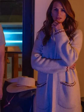 Julia Roberts wearing a long wool coat with decorative red stitching on the cuffs and pockets.