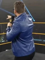 Professional wrestler wearing a blue leather jacket with quilted shoulder detailing.