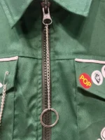 A low-angle shot of Vince Noir performing, wearing a black military-style jacket with silver braided frogging.