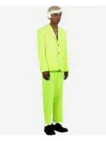 Male model side view wearing Tyler the Creator Igor lime green full suit with blond wig on white background