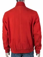 Detailed close-up of the white embroidered logo and traditional toggle-style rope fasteners on a red suede jacket.