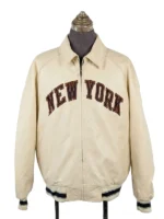 A full-zip collared jacket displayed on a mannequin from a three-quarter angle, featuring bold block lettering across the chest and a patriotic patch on the upper left sleeve.