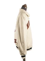 Side profile view of a zippered jacket on a mannequin, showcasing the roomy fit of the sleeve and text peeking from the front and back panels.