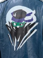 Close-up of the large graphic printed on the back of the blue Johnny Cage leather jacket, featuring a stylized ninja illustration with a purple headband and green sunglasses.