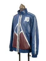 Three-quarter side angle of the blue faux leather Johnny Cage jacket from Mortal Kombat II, displaying the white "JC" chest letters, a silver-striped sleeve, and a maroon geometric accent panel.