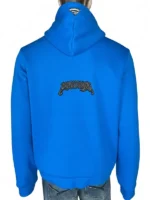 Full back view of a vibrant blue Youngla Superman hoodie displayed on a mannequin. The hoodie features a relaxed fit, a clean back panel anchored by an arched black and white embroidered gothic Youngla logo across the center, and a small black Superman shield patch sewn onto the peak of the hood.