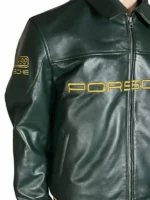 Rear view of the dark green Aimé Leon Dore × Porsche 993 leather jacket on a mannequin. Features a prominent embroidered gold cursive 'Aimé Leon Dore' script across the upper back shoulders and a massive embroidered Porsche Stuttgart coat of arms shield patch filling the center back.