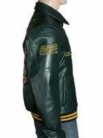 Close-up profile view of the left sleeve on the green Aimé Leon Dore × Porsche 993 leather jacket, magnifying the multi-colored embroidered Stuttgart horse and shield crest emblem.