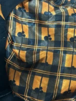 The back of a faded black denim jacket featuring a large, tonal black and charcoal embroidery of Mickey, Donald, and Goofy in Halloween costumes.