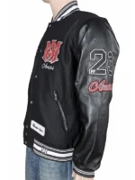 Close-up of a custom recreation Amiri varsity jacket with black leather sleeves and white-and-black striped cuffs.