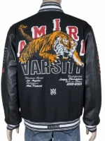 Detailed view of the rib-knitted collar and front button closure of a black Amiri varsity jacket.