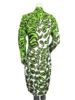 A close-up of the textured fabric on Emily’s green printed coat, showing the intricate floral motifs and the oversized collar detail.