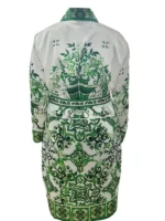 A close-up shot of Nick Jonas smiling, focusing on the intricate silk lapels of a premium burgundy Christmas robe.