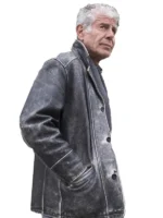 Side profile of Anthony Bourdain wearing his distinct grey Anthony Bourdain field jacket over a scarf.