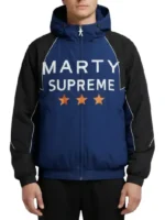 Close-up of the Marty Supreme embroidery and orange star details on the navy jacket.