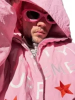 Close-up view of the pink Marty Supreme jacket showing the unique logo stitching.