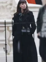 Close-up of Susie Glass in her signature black trench coat from The Gentlemen show, highlighting the tailored shoulders and lapels.