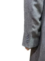 Front view of a long gray trench coat featuring two waist pockets with flaps and a classic tailored silhouette.