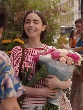 Emily Cooper in a vibrant red geometric print top from her Parisian wardrobe.