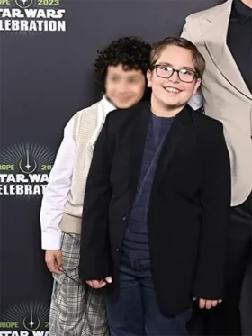 A young boy wearing a neat black blazer inspired by Robert Timothy Smith in Star Wars: Skeleton Crew.