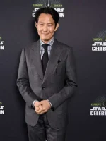 A man wearing a formal grey three-piece suit with a lapel collar inspired by Lee Jung-jae in The Acolyte.