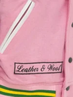 Close-up of the stitched logo on the front of the varsity jacket pink and white.