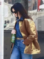 Side view of the Anne Hathaway gold metallic barn jacket showing the relaxed fit.