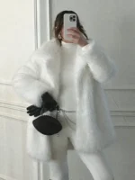 Front view open closure of Kennedy Stidham white vegan fur coat showing relaxed drape, mid-length fit, and cozy winter styling.