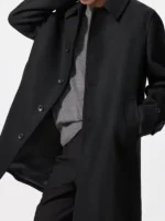 Styling view of the black Balmacaan overcoat worn open for a casual look.