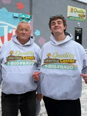 A styling view of the viral grey 1-800-FRAUD Quality Learing Center hoodie.