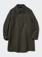 Close-up view of the olive Balmacaan coat collar and raglan sleeve stitching.