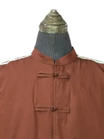 The front view of the Fox Brown Adidas x CLOT Chinese New Year track jacket on a mannequin, highlighting the clean alignment of the mandarin collar, traditional closures, and white rope three-stripes.