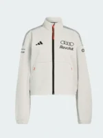 An off-white athletic track top featuring a stand-up collar, black central zipper with a bright orange pull tab, black sports brand logo on the right chest, and the Audi Revolut team logo on the left chest.