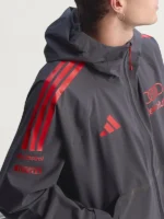 A detailed close-up of the cotton-polyester fabric on the Adidas x Audi rain jacket showing textural narrative integrity.