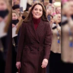Kate Middleton wearing a burgundy plaid coat with a high-neck inner layer at Royal Marsden Hospital appearance