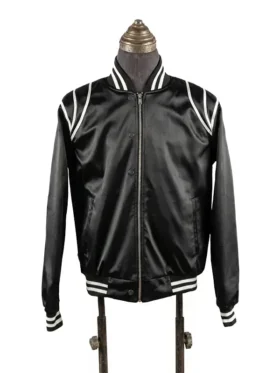 Front view of the black satin Keith Powers The Gates flight jacket on a vintage tailoring mannequin, highlighting the high-luster fabric, central chrome zipper, snap-button flap accents, and distinct striped rib-knit details.
