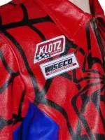 Close-up of a red and blue leather racing jacket featuring spider web patterns and sponsorship patches.