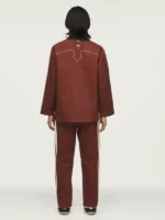 A person showing the premium cotton fit of the fox brown Adidas CLOT jacket.