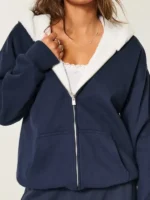 A person wearing the Navy Blue reversible hoodie styled in a modern streetwear look.