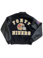 Back view of the black 49ers varsity jacket l 1980 showing the golden helmet logo and varsity lettering.