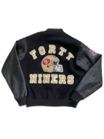 Back view of the black 49ers varsity jacket l 1980 showing the golden helmet logo and varsity lettering.