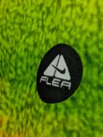 Extreme Macro Detail of Circular Embroidered Black Chest Patch on Textured Neon Green Fleece Fabric Pile