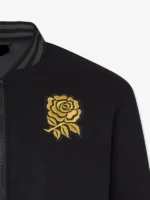 Profile view of the black unisex England Rugby x Undefeated bomber jacket.