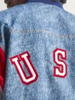 Embroidery detail of Adidas Denim Graphic Track Top highlighting front logo stitching on blue denim fabric
