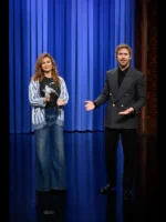 Ryan Gosling in a grey Gucci double breasted jacket holding hands with Eva Mendes on The Tonight Show stage in March 2026.