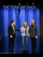 Ryan Gosling laughing with Jimmy Fallon and Eva Mendes while wearing his signature 2026 Gucci double breasted grey coat.
