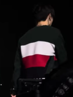 Back view of Jungkook in black Kith varsity jacket showing white and red colorblock panels at BTS Swimside 2026